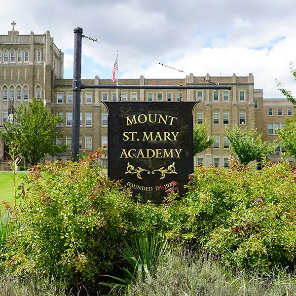 photo of the wooden sign outside of MSM with the the words Mount St. Mary Academy written on it