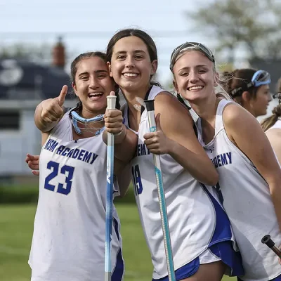 three mounties in lacrosse uniforms posing for a photo smiling with thumbs up