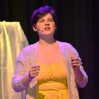 Student acting and singing on stage